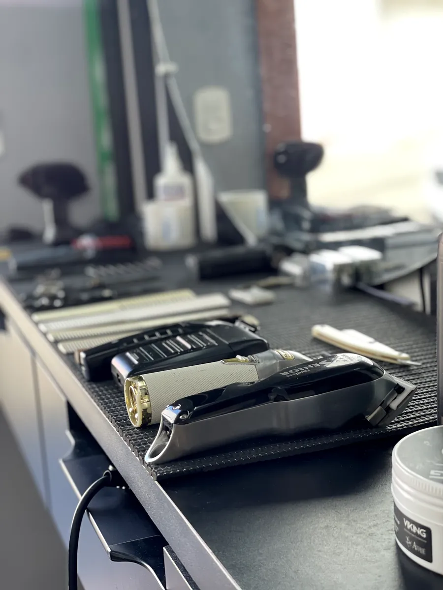 Bancada com as máquinas de corte profissionais da Navalha Barbearia