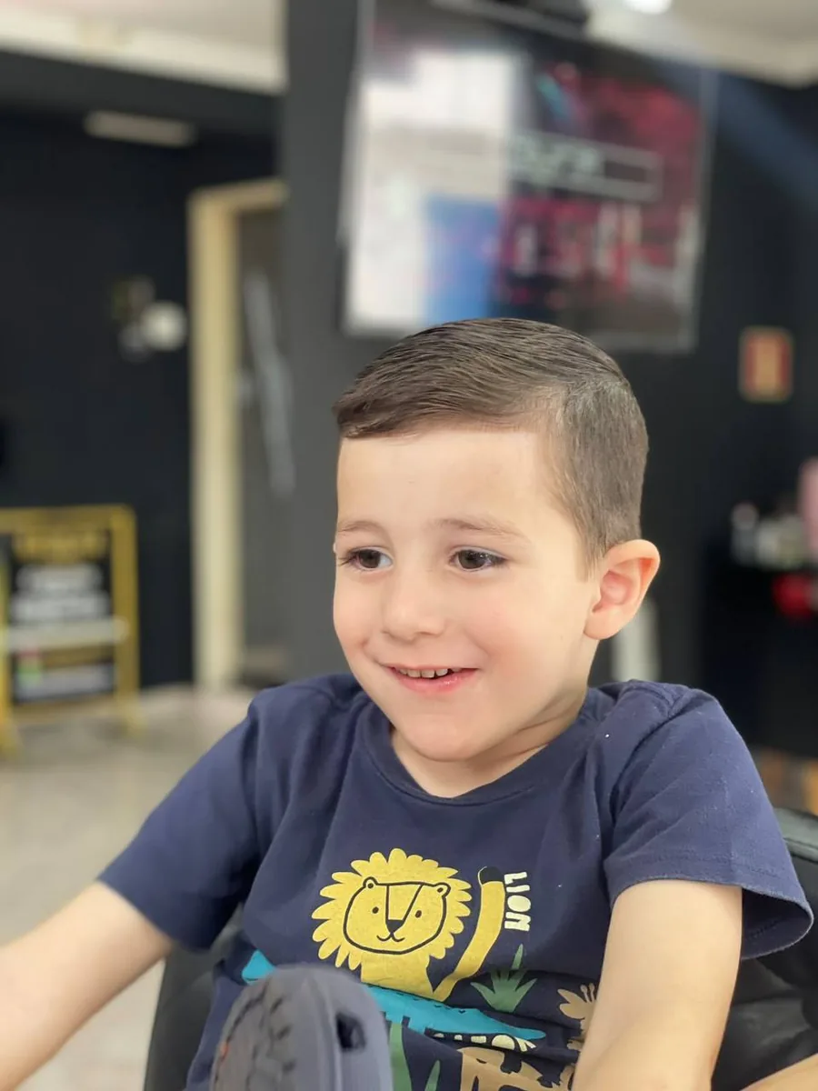 Menino sorrindo depois do corte na Navalha