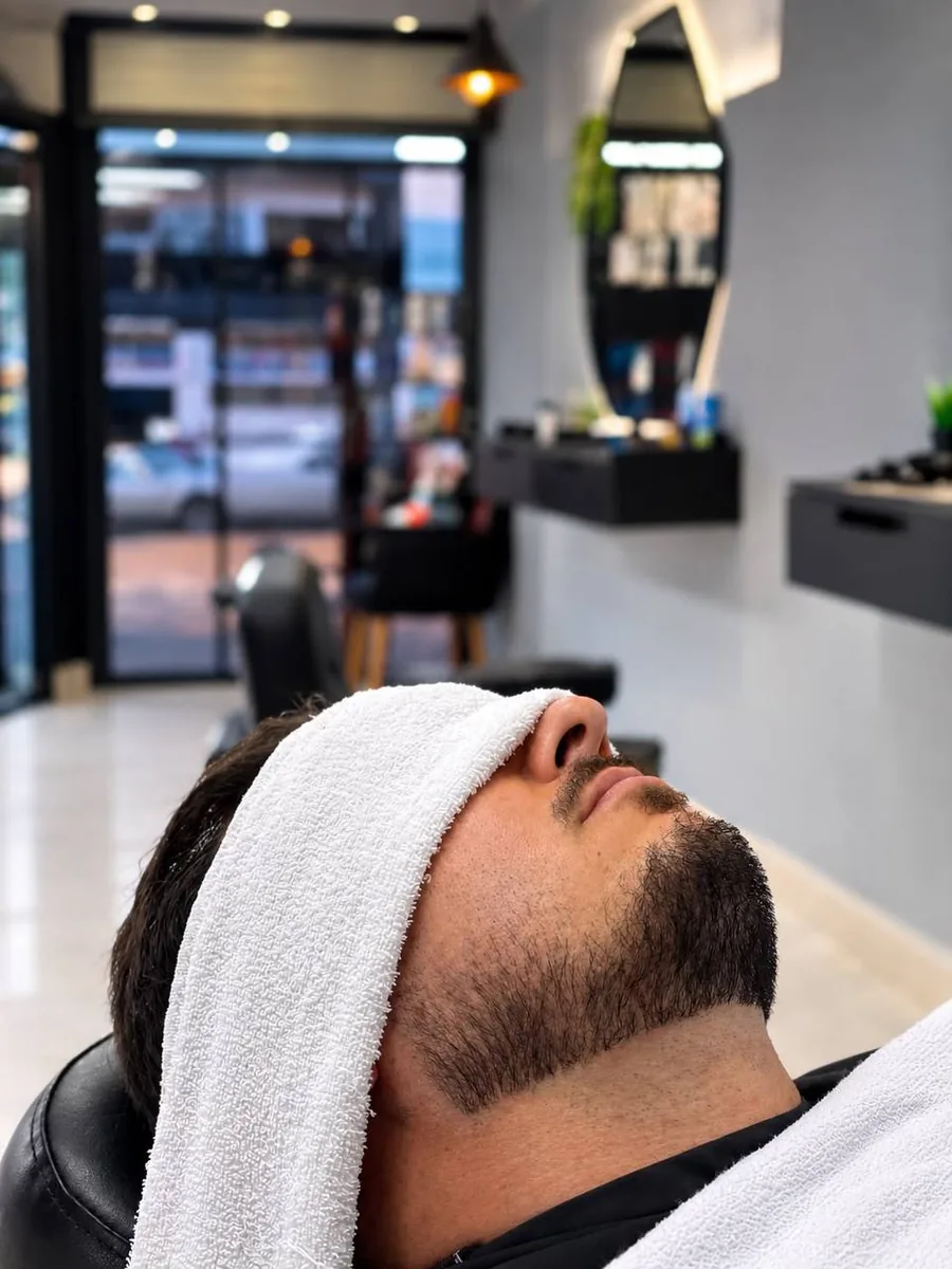 Cliente com toalha quente e barba alinhada